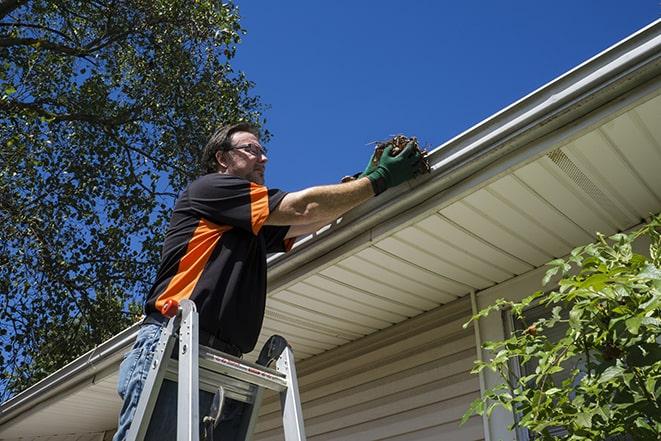 a person repairing a gutter on a residential roof in Alva FL